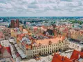 Wrocław słynie z kolorowych kamienic na Rynku i wież kościelnych. Widok z lotu ptaka na tętniące życiem miasto.