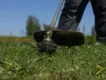 Zbliżenie na głowicę podkaszarki z żyłką, gotową do pracy. Dowiedz się, jak założyć żyłkę do podkaszarki i przywrócić jej moc.