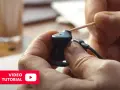 Pokazano, jak wyczyścić słuchawki douszne za pomocą wykałaczki. Wideo tutorial.