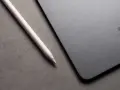 Apple Pencil liegt neben einem iPad mit drei leuchtenden Punkten.