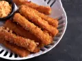 Chrupiące paluszki surimi, panierowane i smażone, podane z sosem. Czy surimi to coś dla Ciebie?