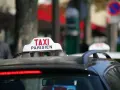 Ein Taxi in Frankreich, mit der Aufschrift "TAXI PARISIEN", wartet auf Fahrgäste.