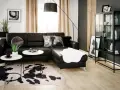 Nowoczesny salon z czarną kanapą i dywanem w cętki. Inspiracje dla odważnych aranżacji.