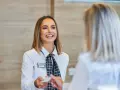 Una sorridente hostess di terra consegna una tessera a un cliente.