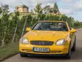Gelber Mercedes SLK R170 Cabrio fährt durch Weinberge, im Hintergrund ein Tempel.