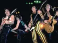 Le groupe Scorpion en pleine performance, des guitaristes aux looks audacieux, sur scène.