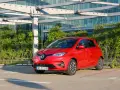Czerwony Renault Zoe, elektryczny samochód miejski, gotowy do jazdy. Jego imponujący zasięg pozwala na swobodne podróżowanie po mieście i poza nim.