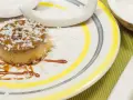 Flan coco on a plate, garnished with coconut flakes and caramel. A perfect dessert for your recette flan coco lait concentré Nestlé.