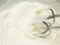 Krem na bazie śmietanki i mascarpone, puszysty i gładki, właśnie ubijany mikserem. Idealny do tortów i deserów.