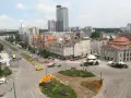 Widok na ruchliwy rynek w Katowicach z tramwajami, samochodami i budynkami.