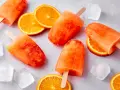 Erfrischendes Aperol Eis mit Orangenscheiben und Eiswürfeln. Perfekt für heiße Sommertage.