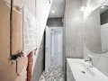 Bagno in ristrutturazione con impianto idraulico a vista, pronto per la detrazione 65. Pavimento decorato e lavabo moderno.