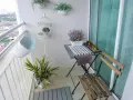 Schöne Balkon Ideen: Ein kleiner Tisch mit Stühlen, Pflanzen in Körben und eine dekorative Vogelkäfig schaffen Gemütlichkeit.