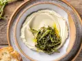 Crema di fave e cicoria saltata, servita su un piatto rustico con pane croccante.