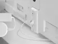 En vit Chromecast med strömkabel och HDMI-anslutning till TV:n. Enheten är redo för chromecast setup wifi.