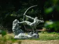 La sculpture de l'archer, une œuvre d'Antoine Bourdelle, se dresse fièrement dans un jardin verdoyant, capturant l'instant d'une tension parfaite.