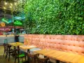 Wnętrze restauracji z zieloną ścianą i wygodnymi lożami. Idealne miejsce na odkrycie najlepszych restauracji w Krakowie - Ranking top 6.