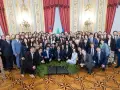 Un folto gruppo di giovani studenti posa per una foto di gruppo, forse dopo un evento alla scuola di giornalismo Roma.