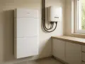 Nowoczesny magazyn energii do domu, biały, modułowy, zamontowany na ścianie obok falownika.
