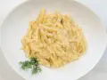 Ravioles val varaita, pasta fresca condita con una cremosa salsa al formaggio e pepe nero, guarnita con timo fresco.