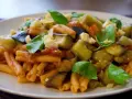 Pyszne danie z makaronem, bakłażanem i pomidorami, posypane serem i bazylią. Idealne na Pasta alla Norma przepis.