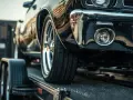 Czarne auto na lawecie, widoczna przednia część i koło.