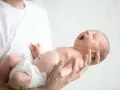 Nowe życie, wielkie ziewnięcie. Maluszek w ramionach taty, czuć jego ciepło. Słychać delikatne chrząkanie u dziecka.