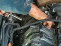 Mechanik naprawia silnik, sprawdzając uszkodzony zawór zwrotny paliwa. Objawy mogą być różne, od problemów z rozruchem po nierówną pracę silnika.