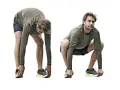 Man utför dynamisk stretching, böjer sig framåt med raka ben och rör vid skorna.