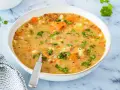Un tazón de sopa de lentejas casera con zanahorias y patatas, perfecto para aprender como hacer lentejas.