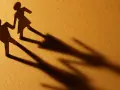 Zwei Papierfiguren, die sich an den Händen halten. Eine Figur scheint sich abzuwenden, während die andere bleibt. Sie sind noch verheiratet und eine neue Beziehung beginnt.