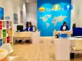 Biuro podróży Coral Travel z pracownicami za ladą i mapą świata na ścianie.