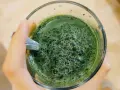 Zielony napój w szklance, pełen bąbelków. To pewnie napój z dużą ilością chlorofilu, który nadaje mu intensywny kolor.