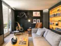 Un salón moderno con bicicleta de carretera colgada, máquina de ciclismo de madera y estanterías iluminadas. Inspiración decoración para deportistas.