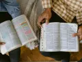 Dwie osoby czytają Biblię, zaznaczając ważne cytaty. Widać fragmenty z Księgi Przysłów.