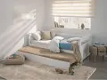 Cama nido blanca con colchones, cojines y manta en un dormitorio juvenil.