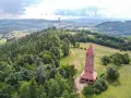 Wieża widokowa w górach zaprasza na podziwianie krajobrazu. W oddali widać maszt telekomunikacyjny.