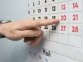 Palec wskazuje datę 20 na kalendarzu. Czas na podjęcie decyzji o okresie wypowiedzenia umowy o pracę.