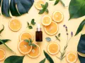 Siero viso con niacinamide e acido glicolico, circondato da fette d'arancia, foglie verdi e lavanda.