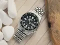 Zegarek diver z czarną tarczą i metalową bransoletą. Niezawodny mechanizm Seiko, gotowy na każdą przygodę.
