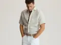 Męskie stylizacje na lato: lniana koszula i białe spodnie tworzą lekki, stylowy zestaw.
