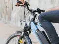 Osoba na rowerze elektrycznym, który jest pojazdem mechanicznym, jedzie po mieście.