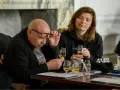 Mann mit Brille prüft ein Glas mit bernsteinfarbenem blended malt whisky. Eine Frau im Hintergrund hält ebenfalls ein Glas.
