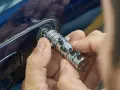 Specjalista manipuluje zamkiem, by otworzyć auto. Dowiedz się, ile kosztuje awaryjne otwieranie samochodu.
