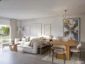 Salón moderno con sofá blanco, mesa de comedor y arte abstracto. Las medidas del salón permiten una distribución cómoda.
