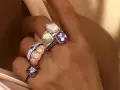 Dita adornate con anelli che esaltano il loro fascino, un vero **materiale prezioso** che cattura la luce.