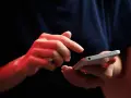 Dłonie z czerwonym podświetleniem obsługują smartfon, być może ustawiając **direct debit** na rachunki.