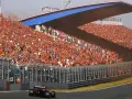 Un coche de Fórmula 1 compite en el Dutch Grand Prix ante una multitud masiva vestida de naranja.