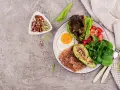 Śniadanie keto: jajko sadzone, bekon, awokado, sałatka z truskawkami i orzechy. Idealne na początek dieta ketogeniczna.