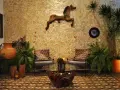 Un caballo decorativo adorna la pared de un patio exterior, complementado por plantas exuberantes y un rincón acogedor.